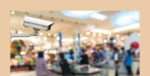 A security camera at a large store seen with a blurry cashier's counter in the background.